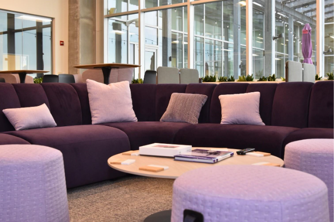 A purple couch with pillows and a round coffee table

AI-generated content may be incorrect.